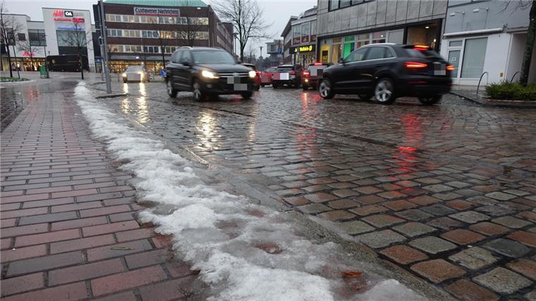 Das befürchtete Chaos durch Glatteis blieb aus Autos fahren auf einer Straße mit Restschnee am Straßenrand