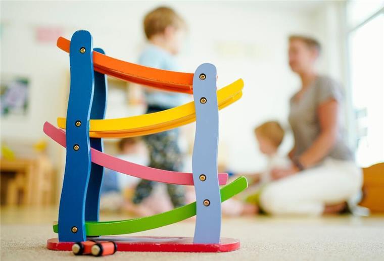 Erzieherin redet Klartext: Diese Kita-Fehler sind für sie ein Kündigungsgrund Eine Erzieherin sitzt mit Kindern hinter einer Murmelbahn und spielt. Eine erfahrene Kita-Erzieherin berichtet über ihre Red-Flags in Kindertagessstätten.