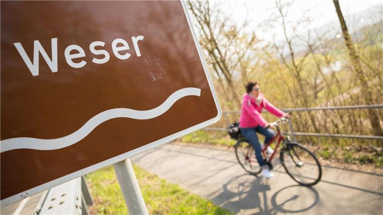 Eine Fahrradfahrerin fährt auf dem Weser-Radweg.