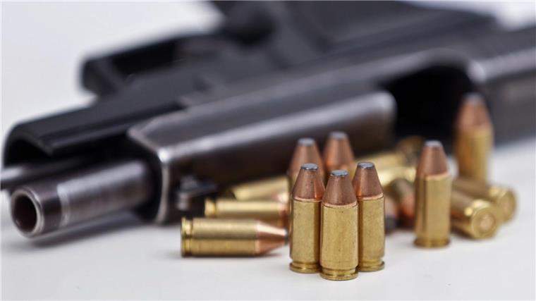 Neue Zuständigkeiten für das Waffenrecht ab 2024 Eine Faustfeuerwaffe liegt mit Magazin und Munition auf einem Tisch.