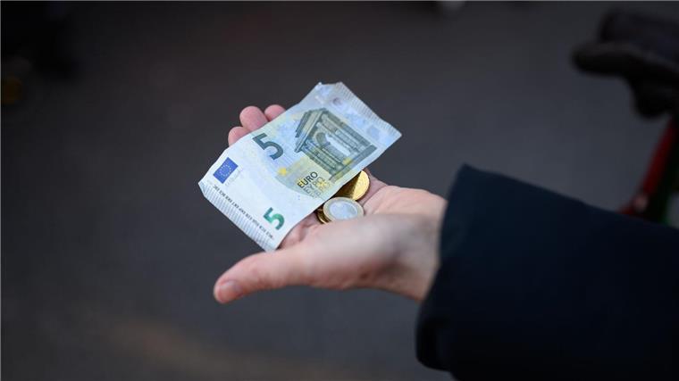 Niedersächsische Wirtschaft 2022 um 1,1 Prozent gewachsen Eine Frau hält das Bargeld für ihren Einkauf in der Hand bereit.