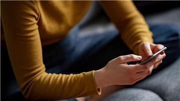 Eine Frau hält ein Smartphone in den Händen.