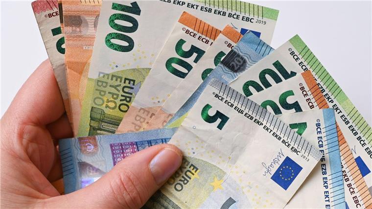 Cewe: Bisher kein verändertes Bestellverhalten Eine Frau hält Geldscheine in der Hand.