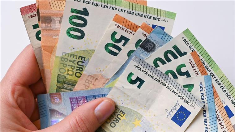 Beamte und Beamtinnen erhalten Sonderzahlungen Eine Frau hält Geldscheine in der Hand.