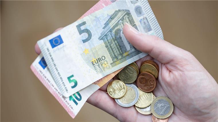 Etwa jeder Sechste in Niedersachsen armutsgefährdet Eine Frau hält Geldscheine und Münzen in der Hand.