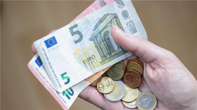 Landesarmutskonferenz warnt vor Spaltung der Gesellschaft Eine Frau hält Geldscheine und Münzen in der Hand.