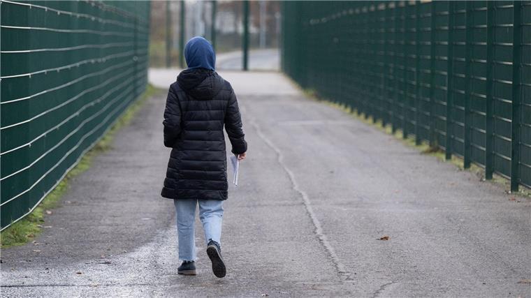 Land Bremen hat 2023 mehr Asylsuchende aufgenommen Eine Frau läuft in einer Erstaufnahmeeinrichtung zu ihrer Unterkunft.