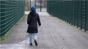 Eine Frau läuft in einer Erstaufnahmeeinrichtung zu ihrer Unterkunft.
