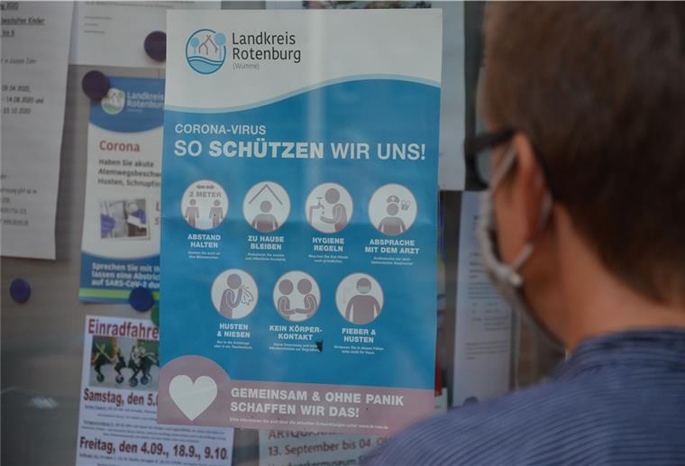 Corona: Die Lage bleibt im Landkreis Rotenburg angespannt Eine Frau liest am Zevener Rathaus ein Plakat mit Empfehlungen des Landkreises zum richtigen Verhalten in der Corona-Pandemie. Nach den jüngst stark gestiegenen Fallzahlen appellieren Gesundheitsamt und Landrat an die Bürger, sich diszipliniert zu verhalten.