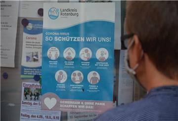Eine Frau liest am Zevener Rathaus ein Plakat mit Empfehlungen des Landkreises zum richtigen Verhalten in der Corona-Pandemie. Nach den jüngst stark gestiegenen Fallzahlen appellieren Gesundheitsamt und Landrat an die Bürger, sich diszipliniert zu verhalten.