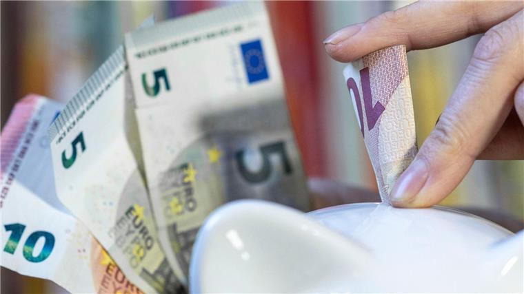 CDU: 300 Millionen Euro im Bremer Haushalt einsparbar Eine Frau steckt einen 10 Euroschein in ein Sparschwein.