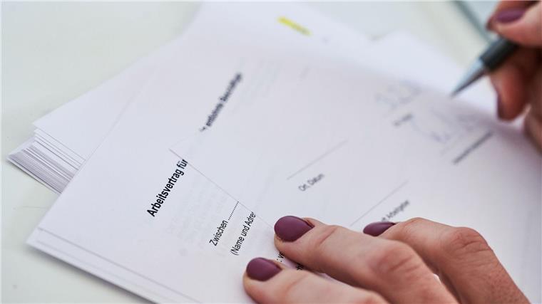 Ampel einigt sich auf digitale Arbeitsverträge Eine Frau unterschreibt einen Arbeitsvertrag.