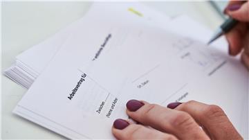 Eine Frau unterschreibt einen Arbeitsvertrag.