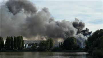 Eine große Rauchwolke breitet sich über einem Gewerbegebiet hinter dem Müggenburger Kanal aus. 