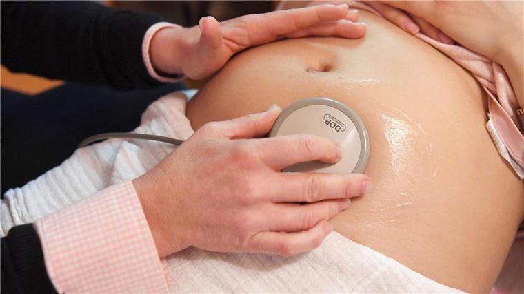 Projekt für mehr Pflegekräfte und Hebammen in Bremen Eine Hebamme hört die Herztöne eines Babys ab.