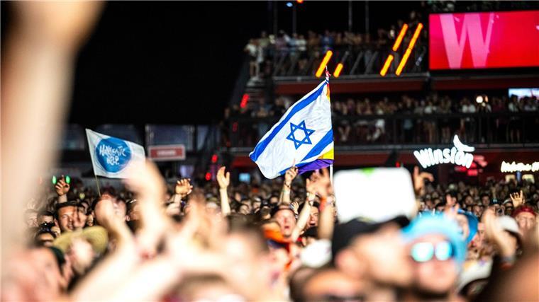 Macklemore wirft Israel bei Festival erneut Völkermord vor Eine Israel-Flagge bei dem Auftritt des US-Rappers Macklemore. Aus dem Publikum erfuhr der Musiker hauptsächlich Unterstützung für seine politischen Botschaften.