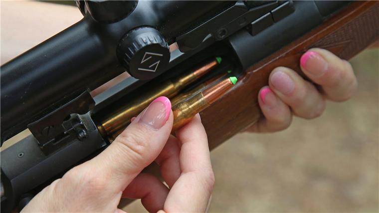 Eine Jägerin lädt ihre Jagdwaffe mit bleifreier Jagdmunition.