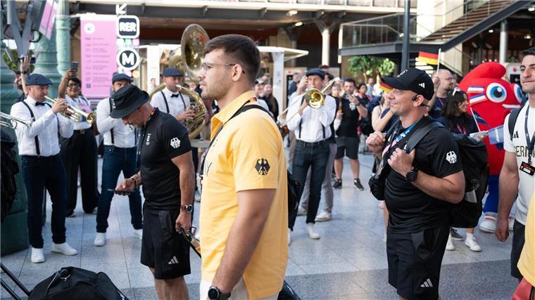Ein Spalier zum Empfang: Olympia-Sportler sind zurück Eine Kapelle verabschiedet das deutsche Olympia-Team mit Musik.