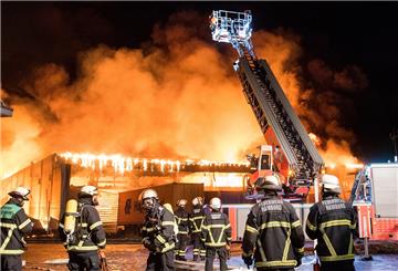 Feuerwehrleute löschen im Stadtteil Wilhelmsburg ein Großbrand. Eine Lagerhalle in einem Gewerbegebiet steht seit dem Morgen im Vollbrand.