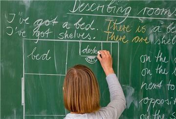 Eine Lehrerin schreibt an die Tafel.