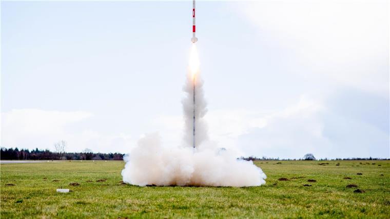 Bester Dosensatellit warnt vor Waldbrandgefahr Eine mit mehreren Minisatelliten bestückte Rakete startet von einer Wiese auf dem Flugplatz.