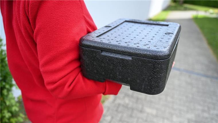 Eine Mitarbeiterin des Deutschen Roten Kreuzes (DRK), die ein Freiwilliges Soziales Jahr absolviert, trägt ein heißes Essen in einer Thermo-Box. (Symbolbild)