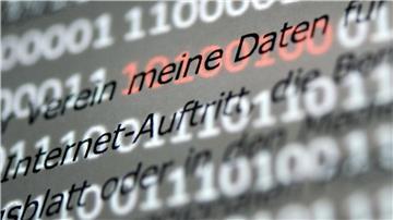 Eine Musterdatenschutzerklärung wird vor einen Bildschirm mit roten Einsen und Nullen gehalten.