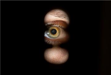 Eine Person schaut durch ein Schlüsselloch einer Tür. Auch Nachbarbarschaft kann zu Stalking ausarten (Symbolbild). Ein Betroffener berichtet vom jahrelangen Leiden seiner Familie.
