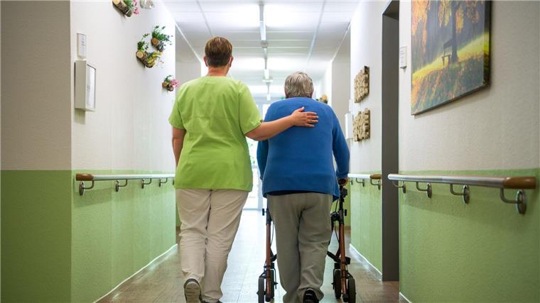 Verbände warnen vor Kollaps in der Pflege in Niedersachsen Eine Pflegefachkraft geht mit einer Bewohnerin durch ein Seniorenheim.