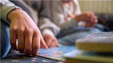 Eine Praktikantin liest in einer Kita Kindern vor.