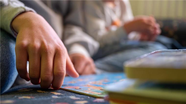 Verband übt Kritik an gesenkten Standards für Kita-Personal Eine Praktikantin liest in einer Kita Kindern vor.