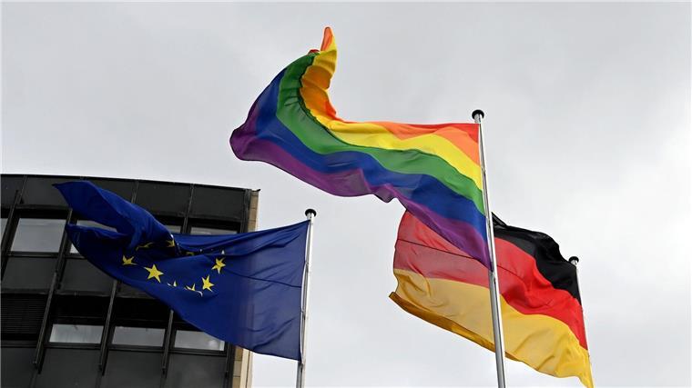 AfD gegen Regenbogenflagge vor öffentlichen Gebäuden: Kritik Eine Regenbogenflagge weht neben einer Deutschlandflagge und einer Europaflagge.