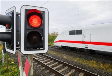 Eine rote Ampel leuchtet an einem Bahnübergang.