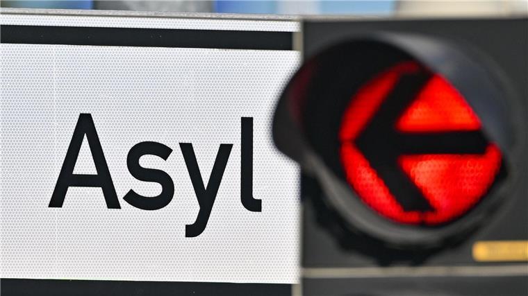 Eine rote Ampel leuchtet vor dem Wort „Asyl“.