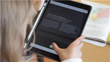 Eine Schülerin bedient ein Tablet mit einer Übersetzungssoftware im Erdkundeunterricht in einem Unterrichtsraum einer Grund- und Oberschule.