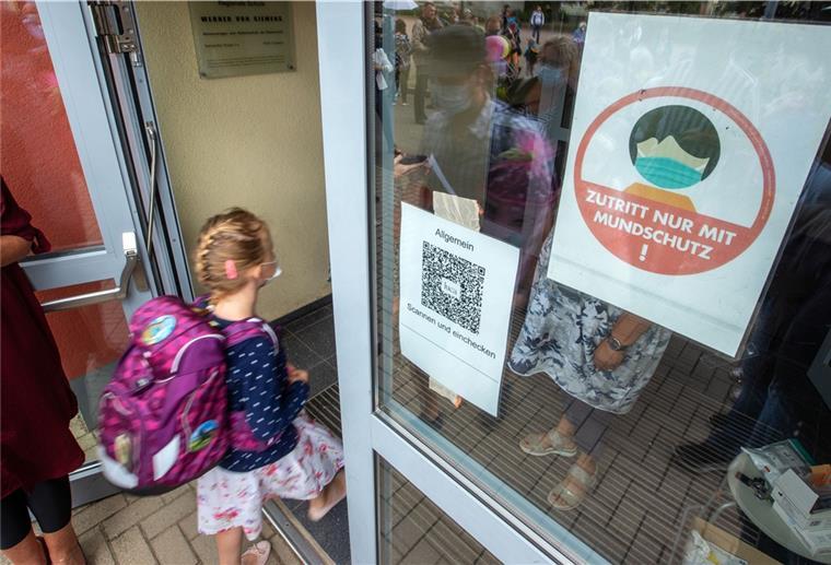 Bundesländer heben Maskenpflicht in Schulen auf Eine Schülerin betritt mit Mund-Nasen-Schutz zur Einschulungsfeier das Schulgebäude.