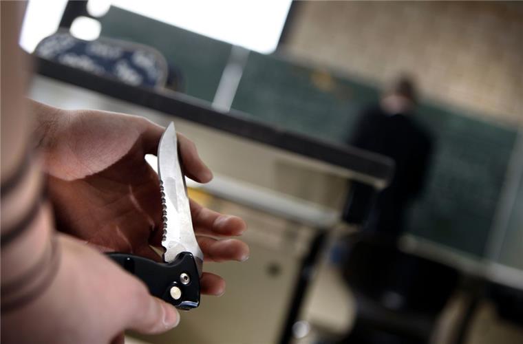 Eine Schülerin zeigt an einem Gymnasium während des Unterrichts einer Mitschülerin ihr Klappmesser. Die Gewalt gegen Lehrer hat in Niedersachsen erheblich zugenommen.