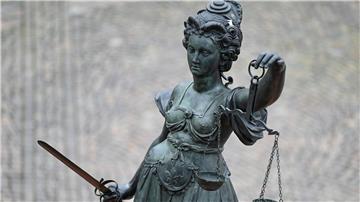 Eine Statue der Justitia hält eine Waage und ein Schwert in der Hand.