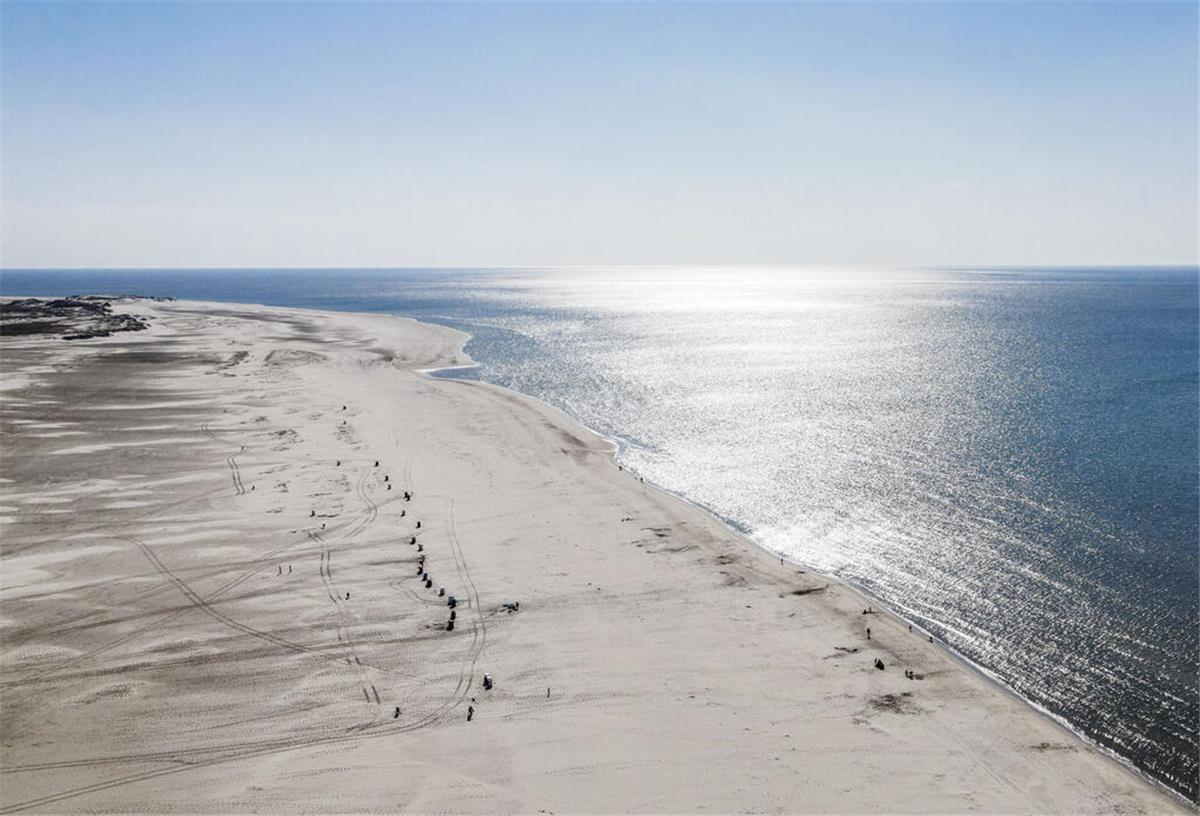 Die Sonne scheint auf den Strand von Norddorf auf der Nordseeinsel Amrum.