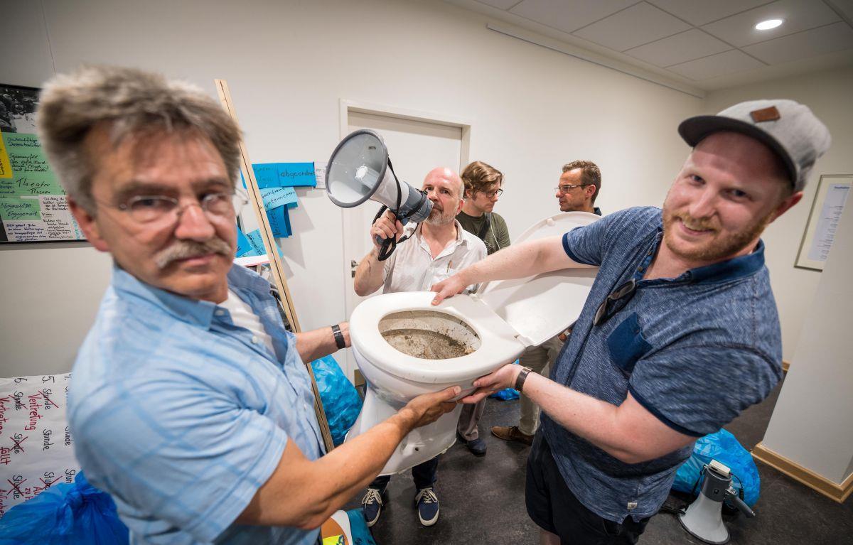20 Bremerhavener Lehrer laden bei Schulstadtrat ihren Schrott ab Eine Toilettenschüssel als Symbol: Bernd Winkelmann von der Gewerkschaft GEW (links) und Thorben Cordes, Lehrer an der Oberschule Carl von Ossietzky (rechts), haben die Uralt-Toilette als Zeichen für den Sanierungsstau an den Schulen zur Schrott-Aktion mitgebracht.