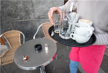 Ein Kellner räumt einen Tisch in einem Restaurant ab. 