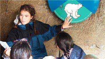Eine Zooschulmitarbeiterin mit einer Gruppe während einer Expedition