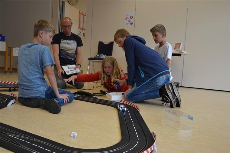 Tarmstedt: Schüler veranstalten Carrerabahn-Rennen in der Bücherei Einen Nachmittag ohne Handy und Computer: Bei einer Ferienspaßaktion in der Bücherei in Tarmstedt zeigt Jan Holsten (zweiter von links), wie man eine tolle Rennstrecke baut.