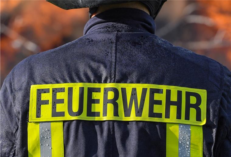 Wulsdorf: Wohnwagen steht in Flammen Ein Mitglied der Freiwilligen Feuerwehr Sieversdorf sichert ein großes Lagerfeuer ab.