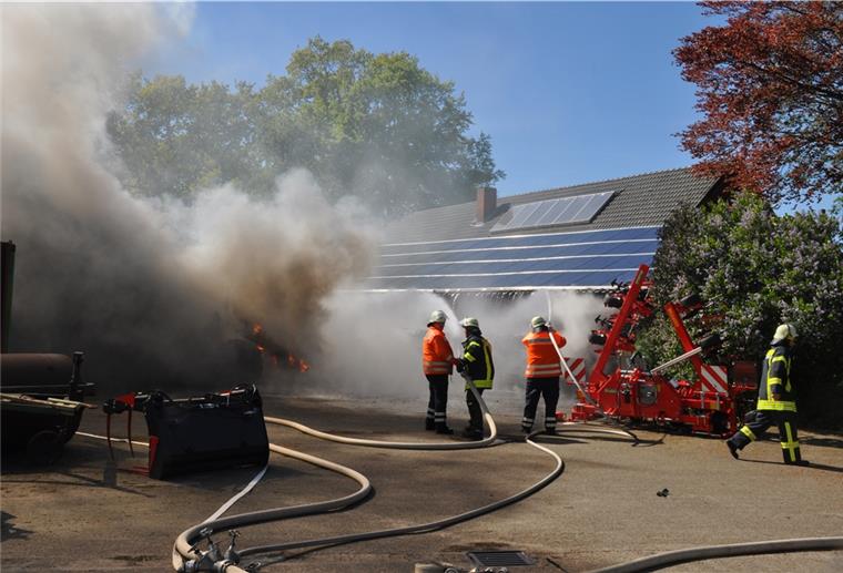 Glinstedt: Traktor steht in Flammen Einsatzkräfte der Feuerwehr kühlen die Fotovoltaikanlage auf einem der gefährdeten Gebäude mit Löschwasser.