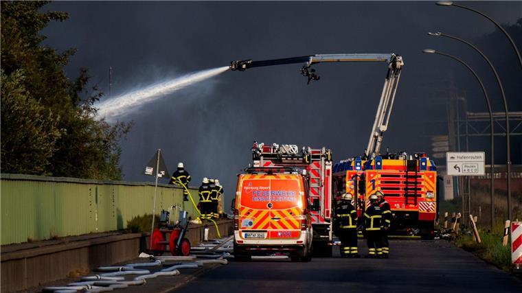 Einsatzkräfte der Feuerwehr versuchen, einen Brand in einem Industriegebiet im Hamburger Hafen zu löschen.
