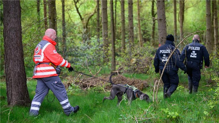 Vermisster Arian lief allein durch Wohngebiet Einsatzkräfte des Deutschen Roten Kreuzes sind mit einem Suchhund in einem Waldstück im Einsatz.
