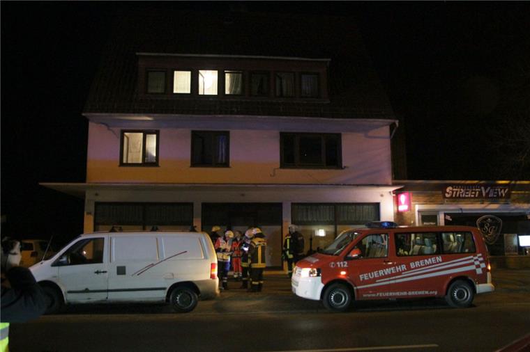 Im Keller gegrillt: Sieben Menschen in Bremen schwer verletzt Einsatzkräfte des Rettungsdienstes und der Feuerwehr stehen vor dem Haus in Bremen-Farge, in dem bei einem Grillabend im Keller acht Menschen teils lebensgefährlich verletzt worden sind,
