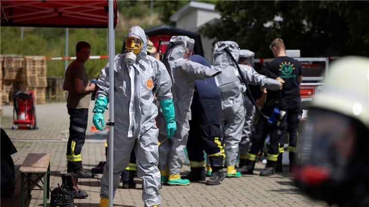 Einsatzkräfte in speziellen Schutzanzügen sind im Einsatz. 