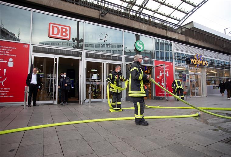 Rauch am Zug: Kölner Hauptbahnhof gesperrt Einsatzkräfte der Feuerwehr stehen mit Wasserschläuchen vor dem Kölner Hauptbahnhof.